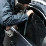 Homeless thief steals purse valuable items from car with unlocked doors open.
