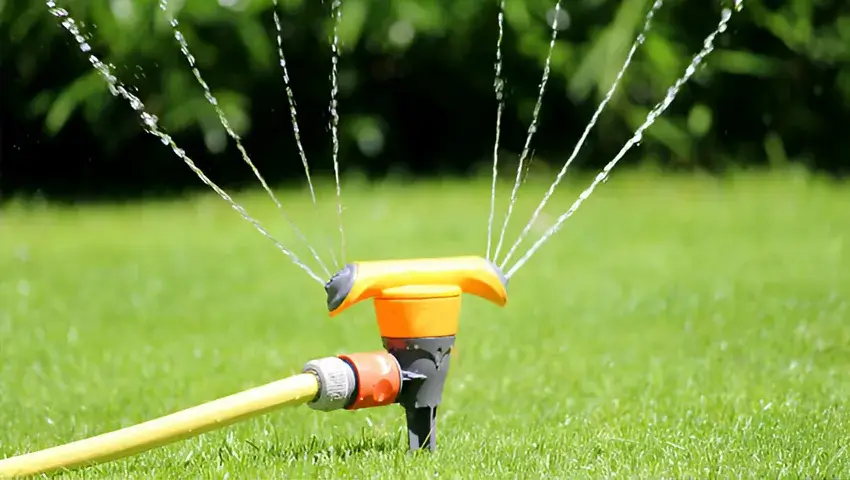 garden sprinkler spraying water, watering lawn grass, flowers