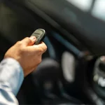 Hand presses unlock on the car remote control